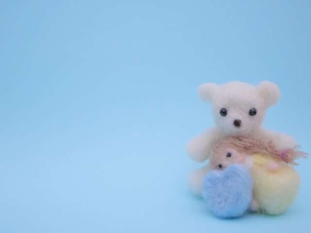 羊毛で作られたクマが子どもを慰める図